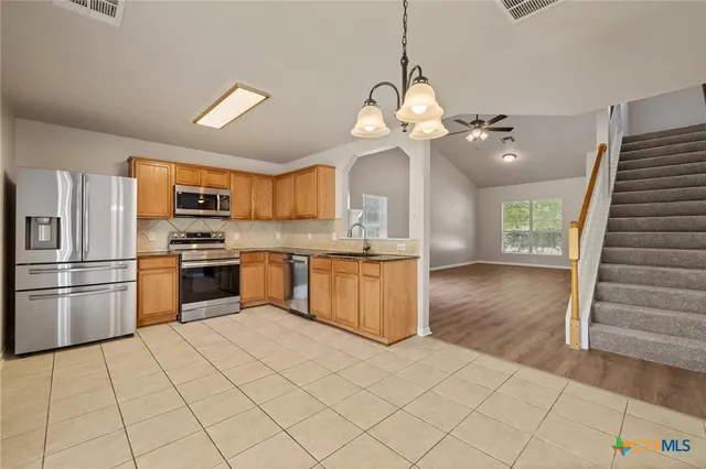 a large kitchen with cabinets and stainless steel appliances