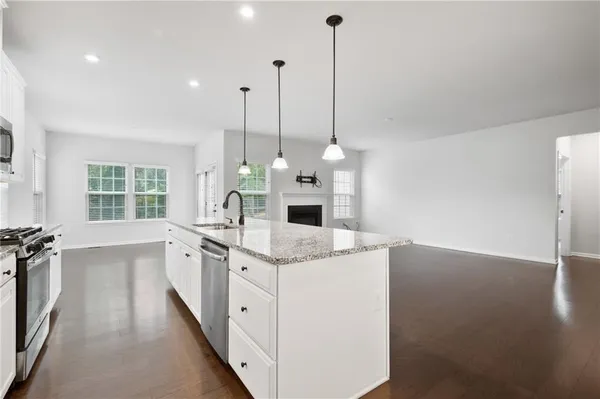 a kitchen with a sink stove and wooden floor