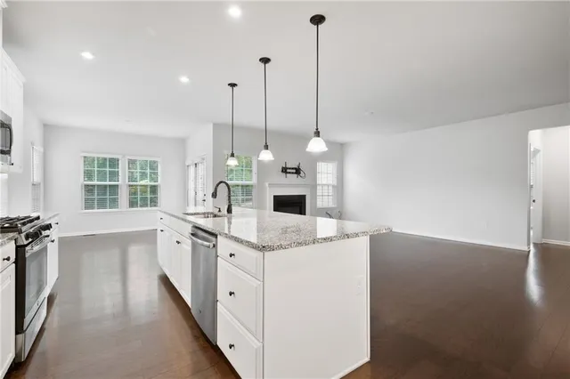 a kitchen with a sink stove and wooden floor