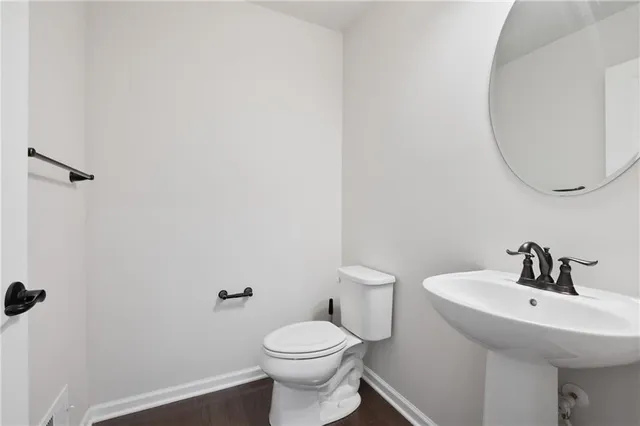 a bathroom with a sink a toilet and mirror