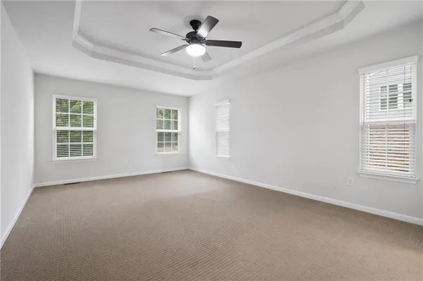 an empty room with a window and a ceiling fan