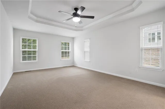 an empty room with a window and a ceiling fan