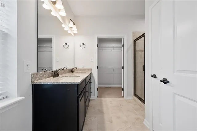 a bathroom with a sink and mirror with shower