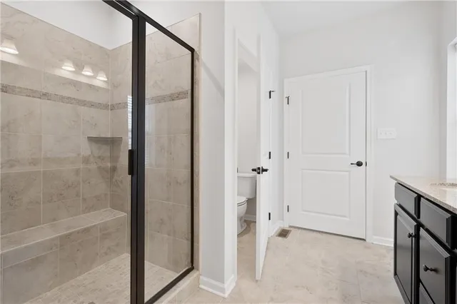 a bathroom with a shower and a glass door