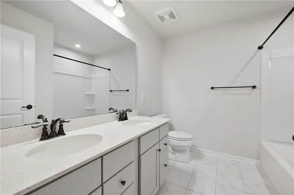 a bathroom with a sink toilet vanity and tub