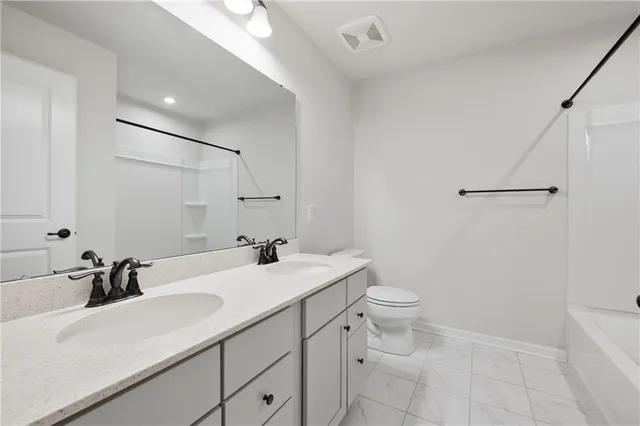 a bathroom with a sink toilet vanity and tub