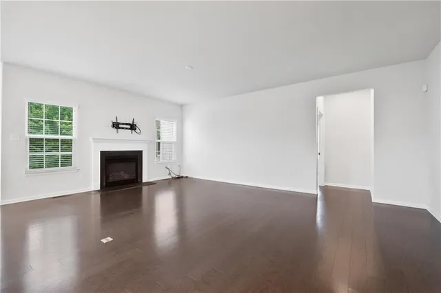 a view of a livingroom with wooden floor and a fireplace