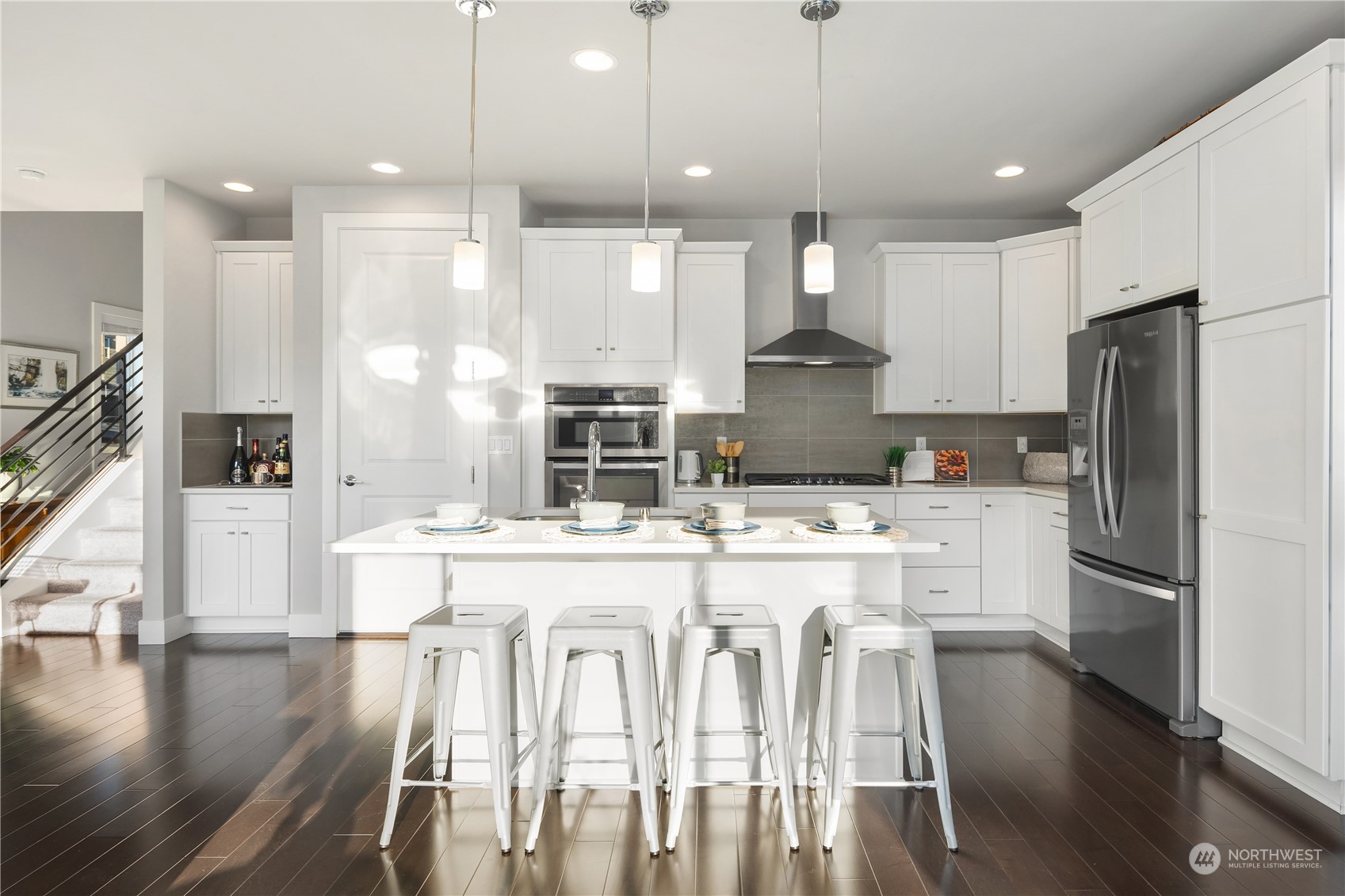 4312 224th Place Southeast Bothell, WA 98021 - Photo 9 of 40 a kitchen with kitchen island wooden floors white appliances and cabinets
