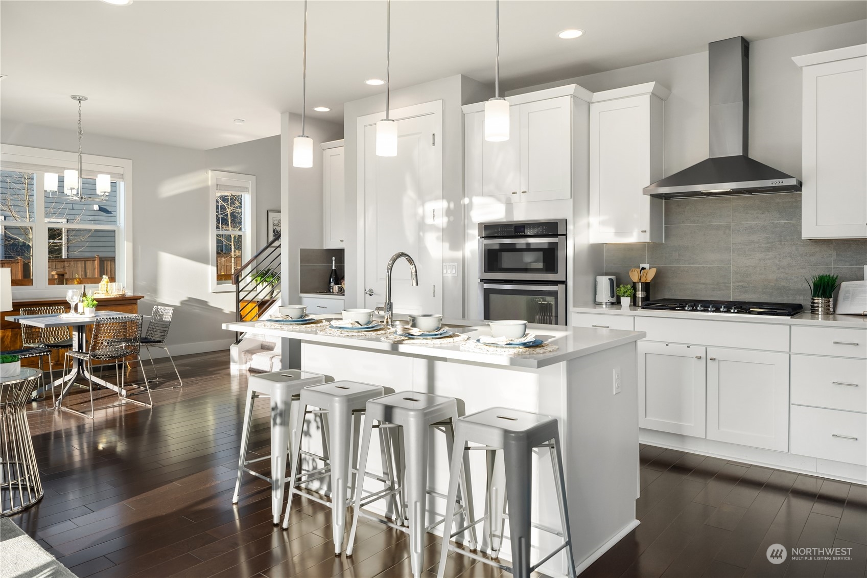 4312 224th Place Southeast Bothell, WA 98021 - Photo 10 of 40 a kitchen with stainless steel appliances kitchen island granite countertop a stove a sink a dining table and chairs with wooden floor