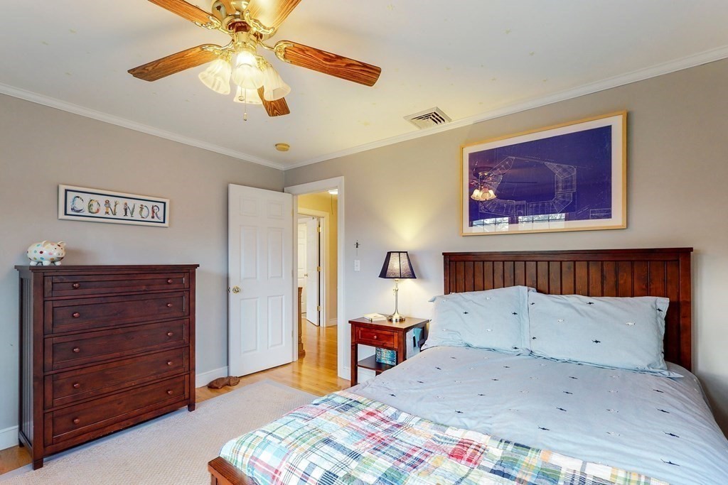 9 Mellen Street Needham, MA 02494 - Photo 29 of 42 a bedroom with a bed and a chandelier
