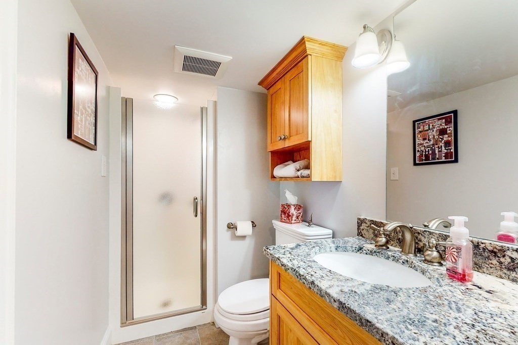 9 Mellen Street Needham, MA 02494 - Photo 35 of 42 a bathroom with a granite countertop sink mirror vanity and toilet