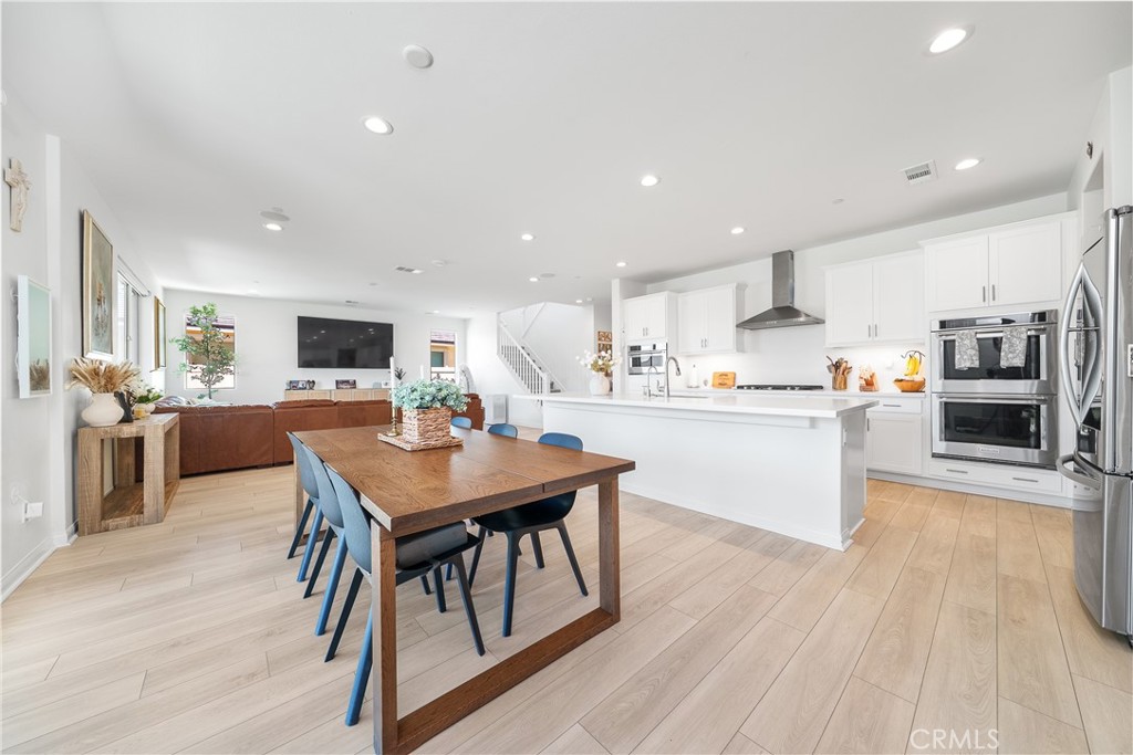 12829 Stags Leap Drive Riverside, CA 92503 - Photo 12 of 54 a kitchen with a table chairs refrigerator and cabinets