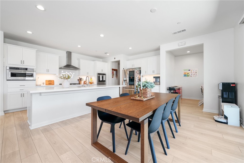 12829 Stags Leap Drive Riverside, CA 92503 - Photo 13 of 54 a kitchen with stainless steel appliances granite countertop a table chairs sink refrigerator and cabinets