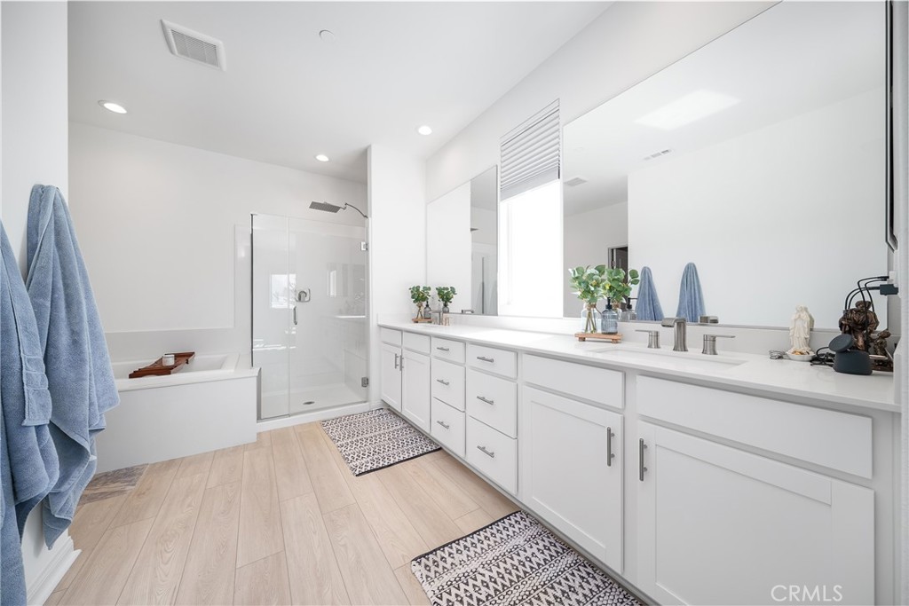 12829 Stags Leap Drive Riverside, CA 92503 - Photo 36 of 54 a spacious bathroom with double vanity a mirror a bathtub and a shower