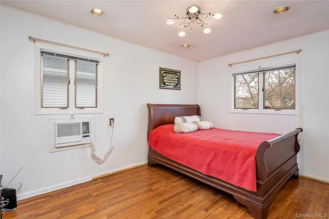 a bedroom with a bed chandelier and a window