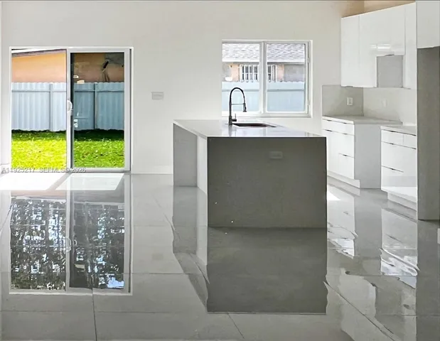 a view of a kitchen with kitchen island and windows