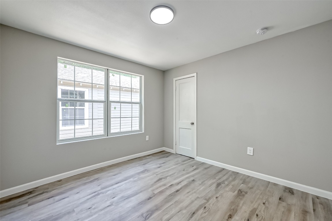 3274 Reeves Street, Unit B Houston, TX 77004 - Photo 2 of 6 an empty room with wooden floor and windows