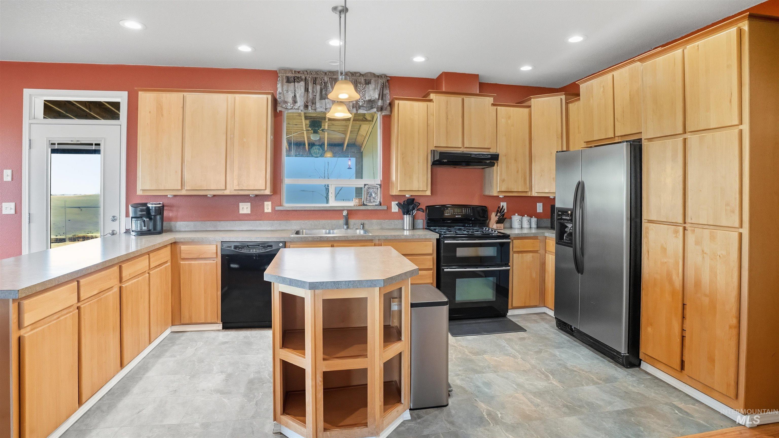 19397 Cloverland Road Asotin, WA 99402 - Photo 6 of 37 Kitchen with black appliances, light wood finish cabinetry, a peninsula, and light countertops
