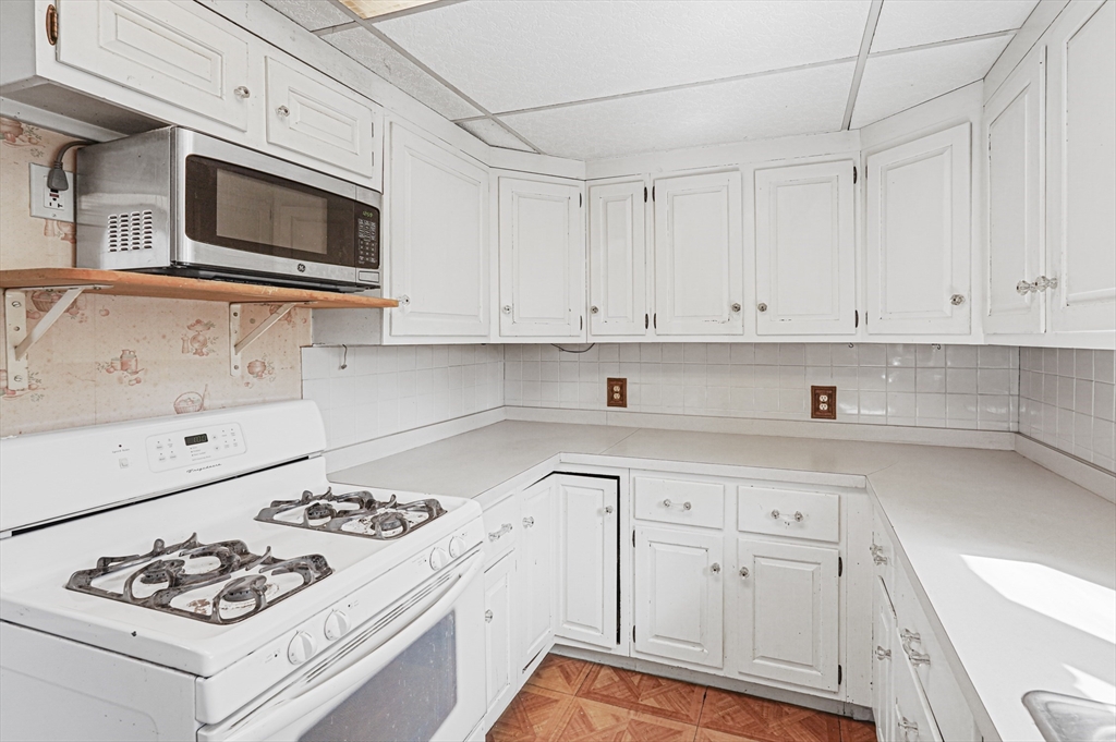 1459 Grafton Road Millbury, MA 01527 - Photo 14 of 42 a kitchen with white cabinets and appliances