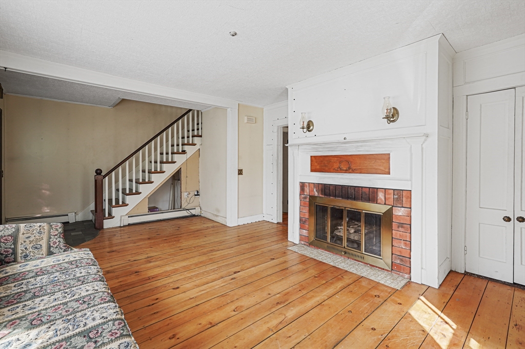 1459 Grafton Road Millbury, MA 01527 - Photo 7 of 42 a view of a livingroom with wooden floor and a fireplace