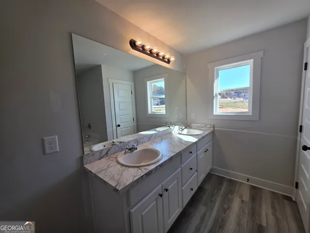 a bathroom with a granite countertop sink a toilet and mirror