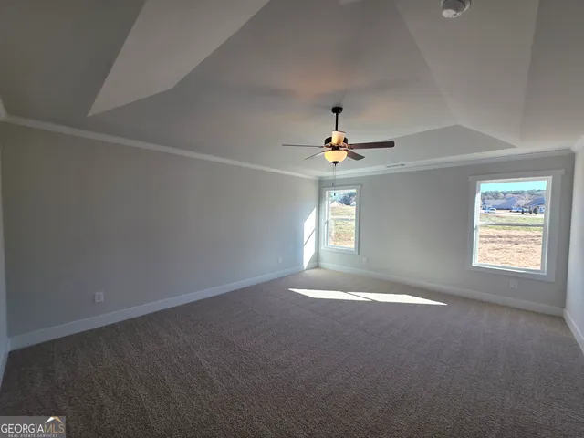 an empty room with windows and chandelier fan