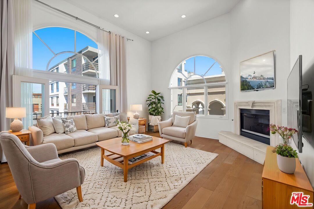 a living room with furniture a fireplace and a large window
