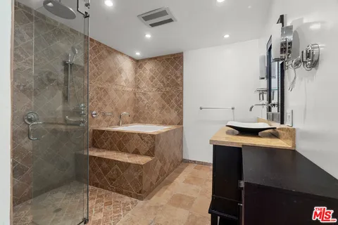 a bathroom with a sink a toilet a mirror and shower