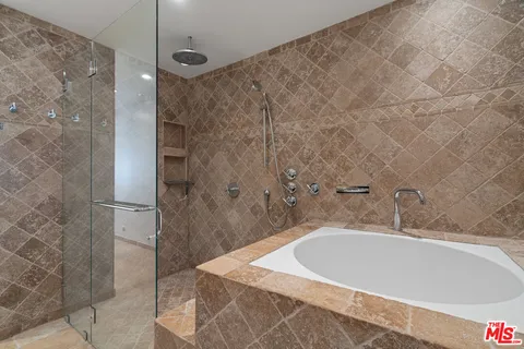 a white bath tub sitting in a bathroom and shower