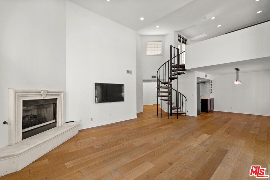 435 Arnaz Drive, Unit 304 Los Angeles, CA 90048 - Photo 18 of 21 a view of an empty room with wooden floor fireplace and a window