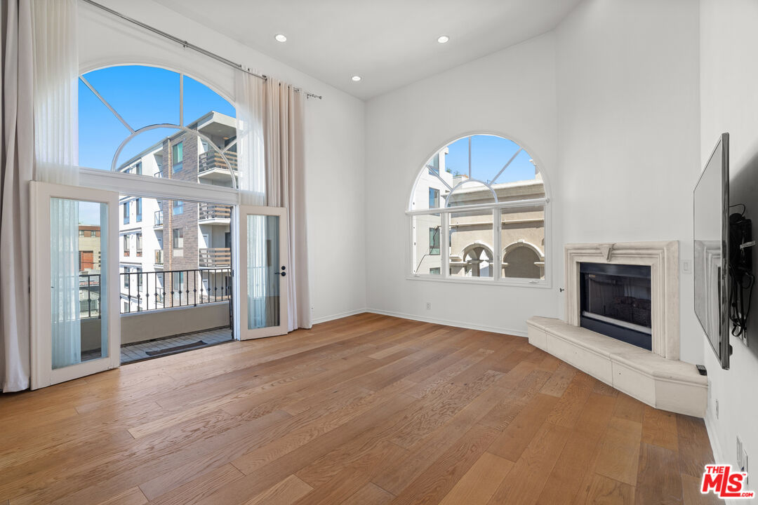 435 Arnaz Drive, Unit 304 Los Angeles, CA 90048 - Photo 7 of 21 a view of an empty room with a fireplace and a window