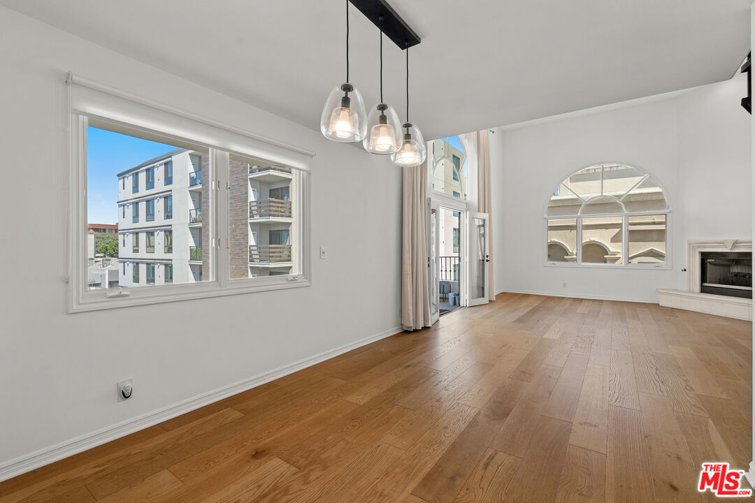 435 Arnaz Drive, Unit 304 Los Angeles, CA 90048 - Photo 8 of 21 a view of empty room with wooden floor and windows