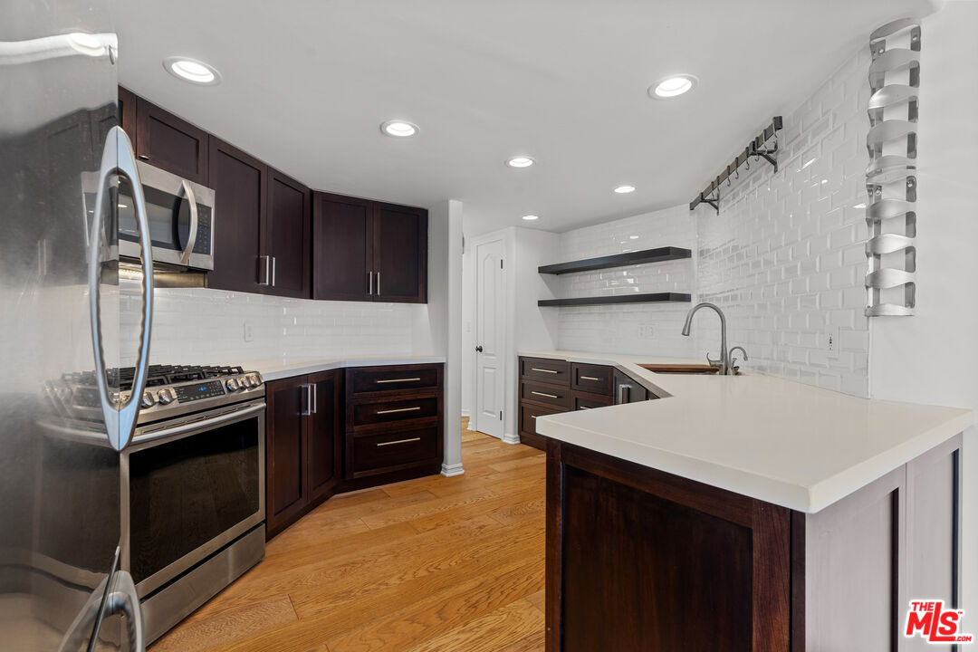 435 Arnaz Drive, Unit 304 Los Angeles, CA 90048 - Photo 10 of 21 a kitchen with stainless steel appliances granite countertop a stove and a refrigerator