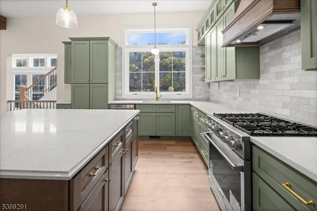 a view of an empty room with kitchen and window