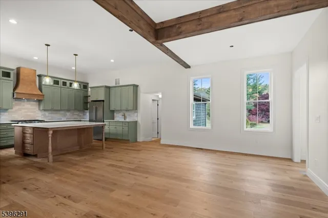 a view of an empty room with wooden floor and a fireplace