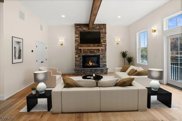 an empty room with wooden floor fireplace and windows