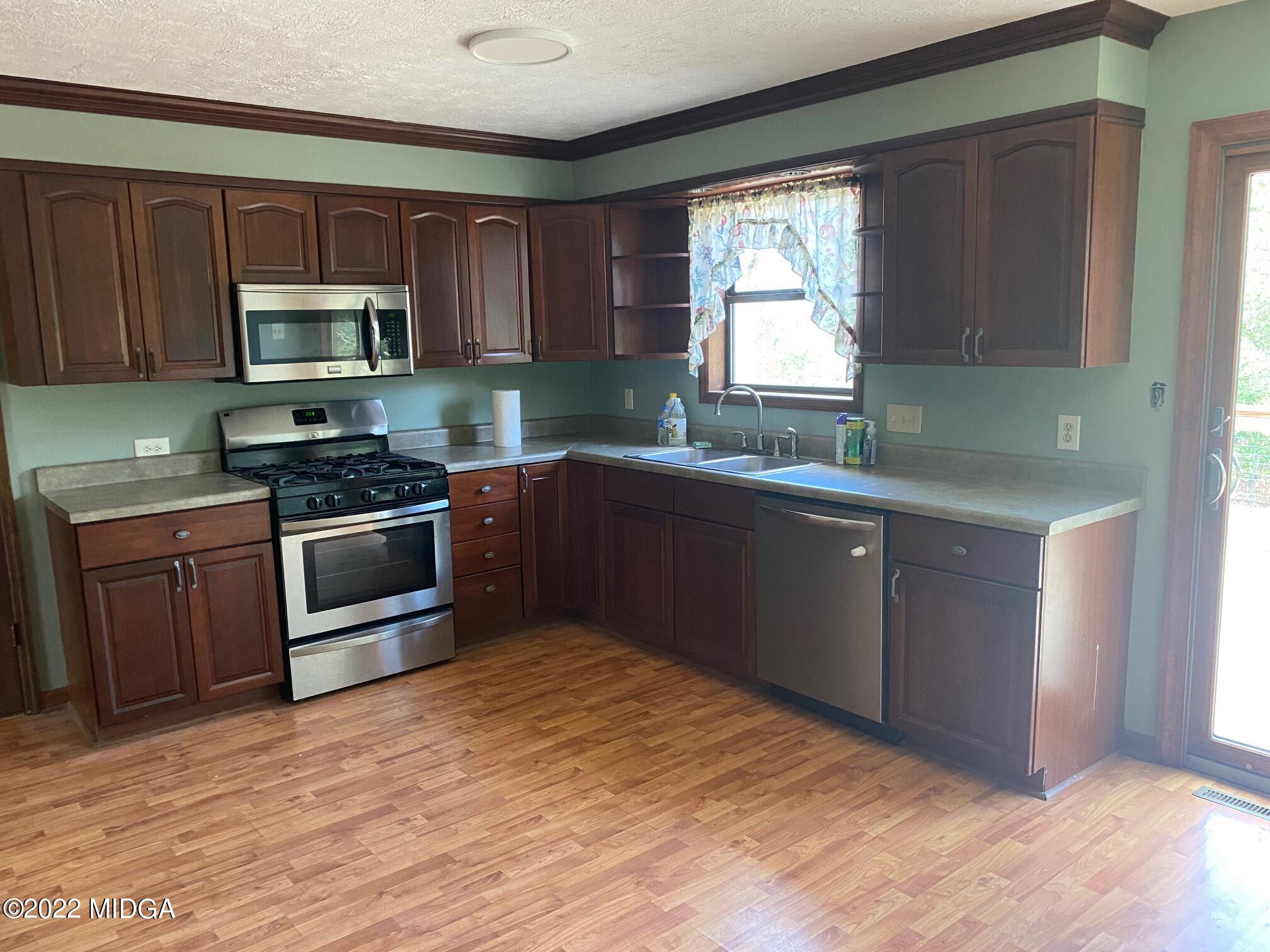 114 Pine Tree Road Macon, GA 31211 - Photo 11 of 18 a kitchen with wooden cabinets stainless steel appliances and a window