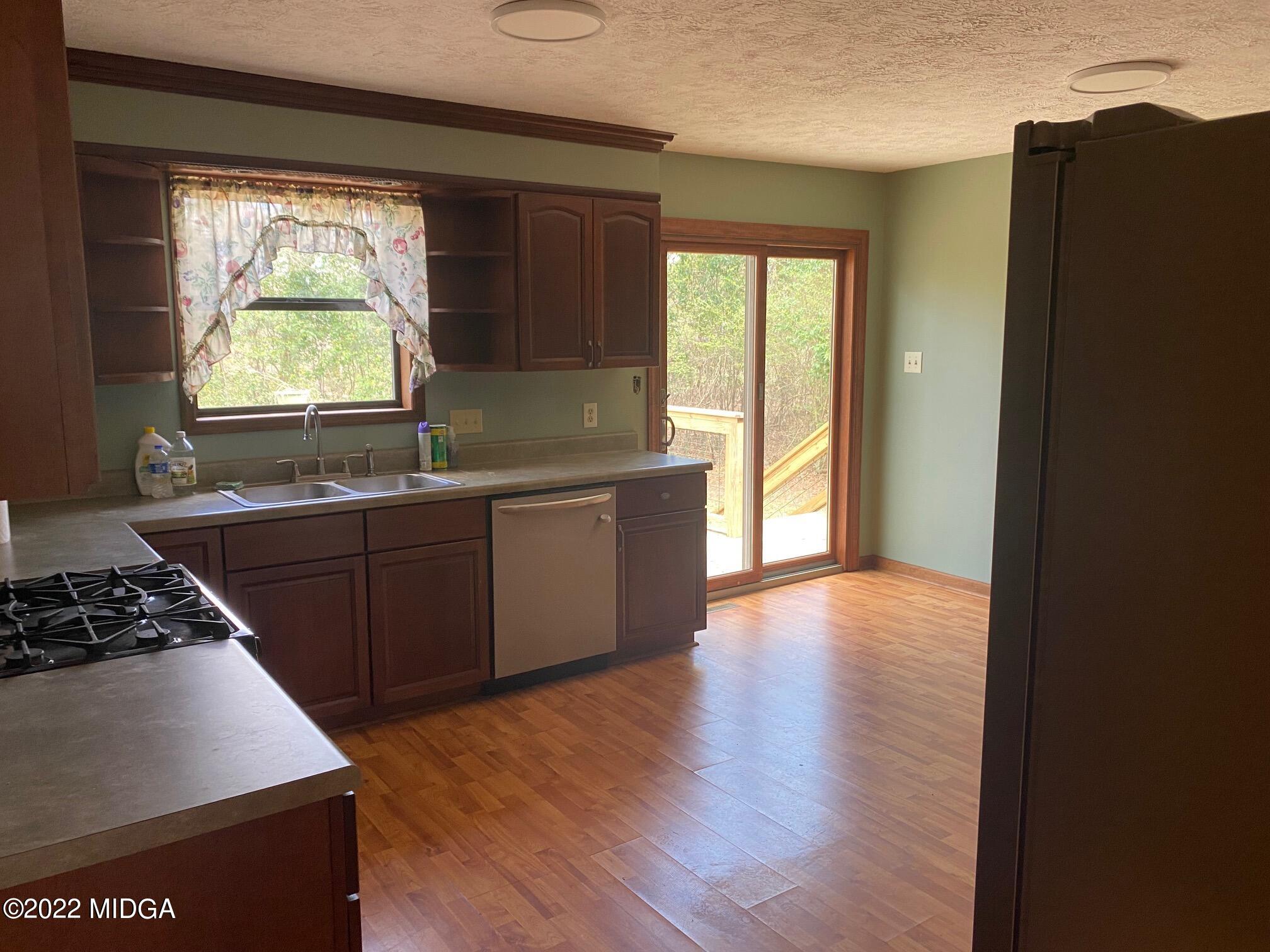 114 Pine Tree Road Macon, GA 31211 - Photo 13 of 18 a kitchen with stainless steel appliances a large window and a refrigerator