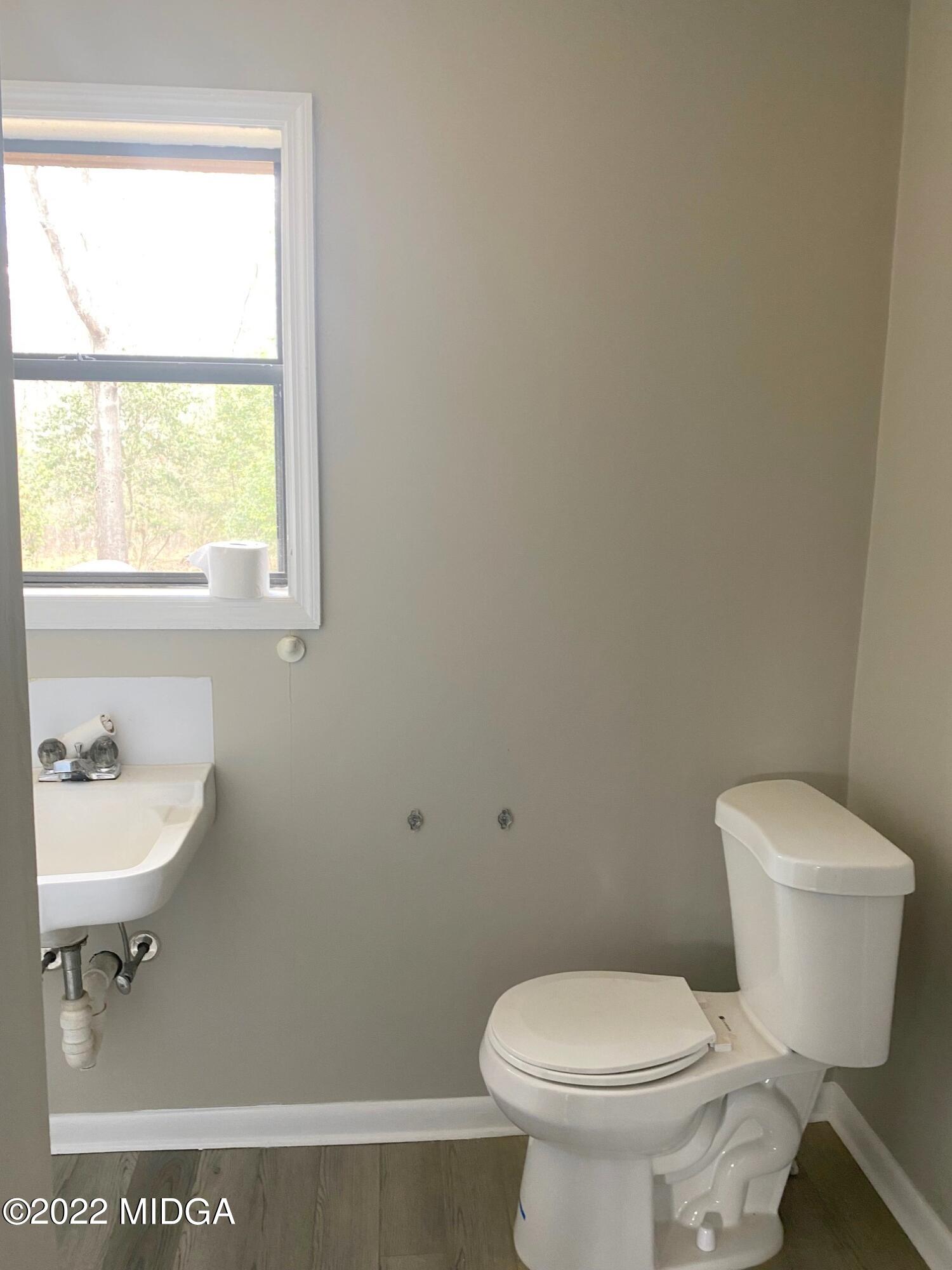 114 Pine Tree Road Macon, GA 31211 - Photo 10 of 18 a bathroom with a toilet a sink and a window