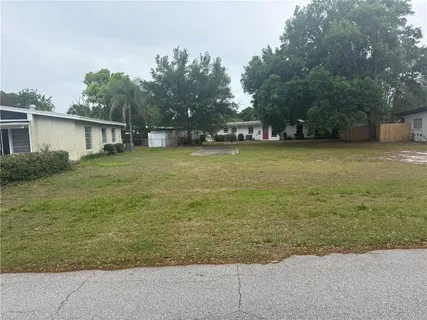 a front view of a house with a garden and trees