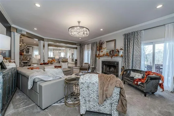 a living room with furniture kitchen view and a flat screen tv
