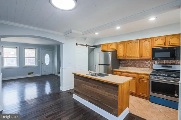 a kitchen with stainless steel appliances granite countertop a stove a sink and a refrigerator