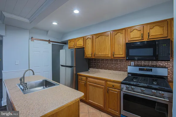 a kitchen with stainless steel appliances a stove a sink and a microwave