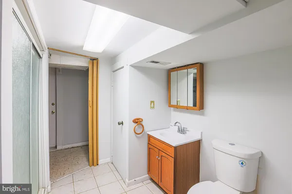 a bathroom with a toilet a sink a mirror and vanity