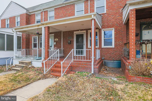front view of a brick house with a yard