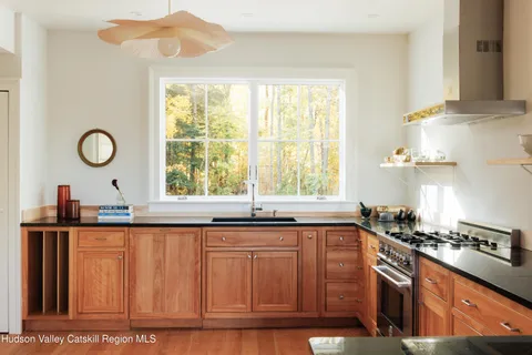 a kitchen with granite countertop a sink a window stainless steel appliances and cabinets