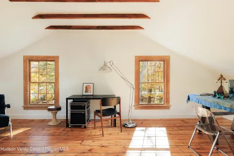 a living room with furniture a desk and chair with windows