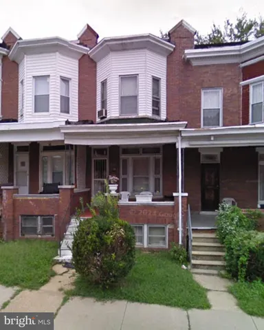 front view of a brick house with a yard