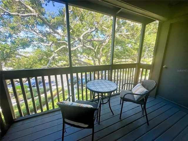 a view of a porch with furniture and wooden floor