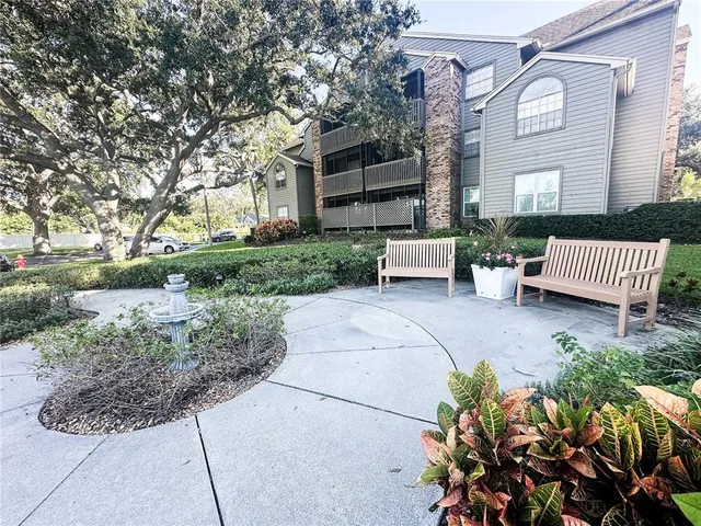 a view of a patio with furniture and a garden